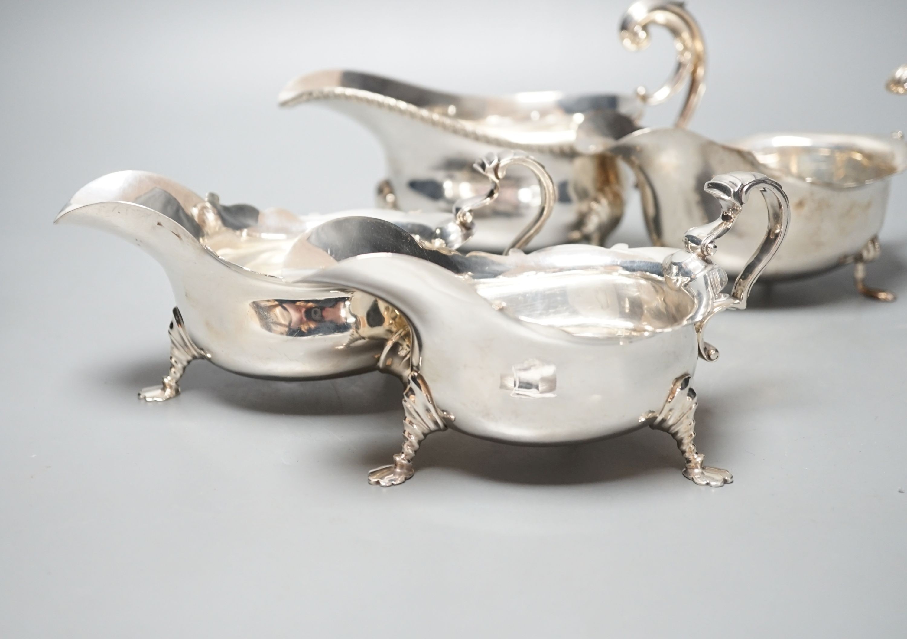 A pair of George V silver sauce boats, London, 1930 and two other larger silver sauceboats, 26oz.